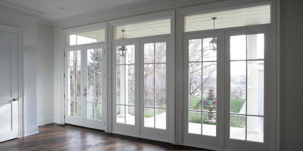 White French-style with divided glass panels, providing abundant natural light and seamless access to a covered outdoor patio and garden